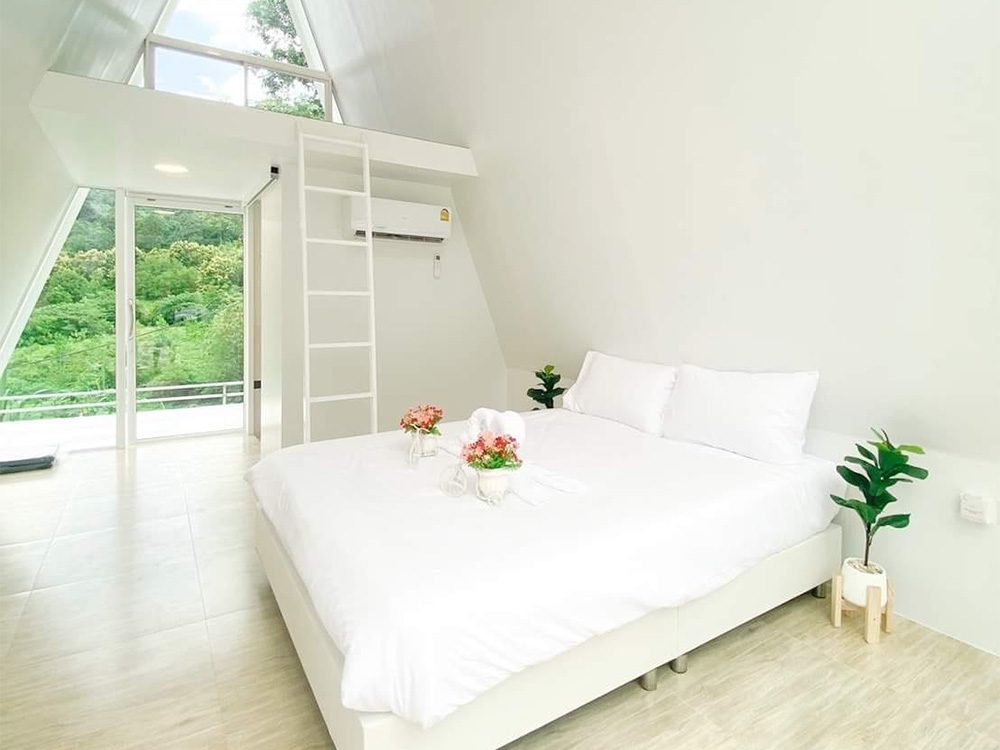 ด้านในห้องพักกับเตียงเดี่ยวสีขาวของ
  A Frame @ น้ำหนาว โฮมสเตย์